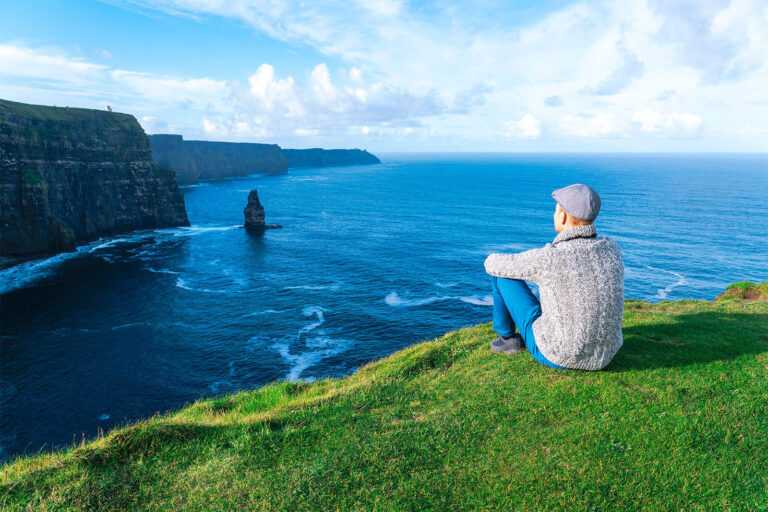 man looking at cliffs of moher